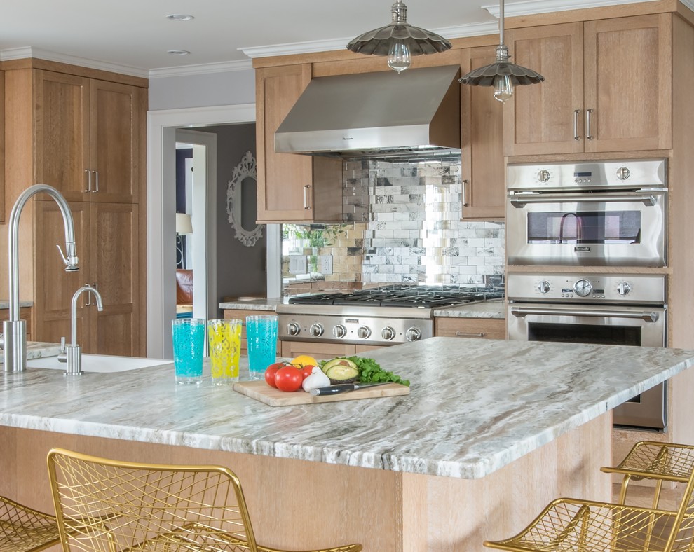 Mid-sized transitional l-shaped light wood floor and brown floor open concept kitchen photo in Boston with metallic backsplash, stainless steel appliances, an island, a farmhouse sink, recessed-panel cabinets, light wood cabinets, marble countertops and subway tile backsplash