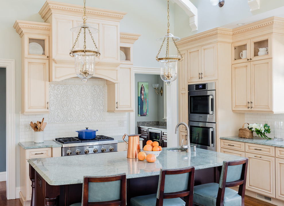 Foto di un cucina con isola centrale vittoriano con lavello sottopiano, ante beige, paraspruzzi bianco, paraspruzzi con piastrelle diamantate e elettrodomestici in acciaio inossidabile