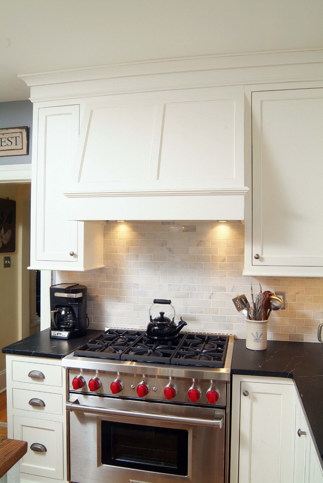 Diseño de cocina de estilo de casa de campo con puertas de armario blancas, encimera de madera y electrodomésticos de acero inoxidable