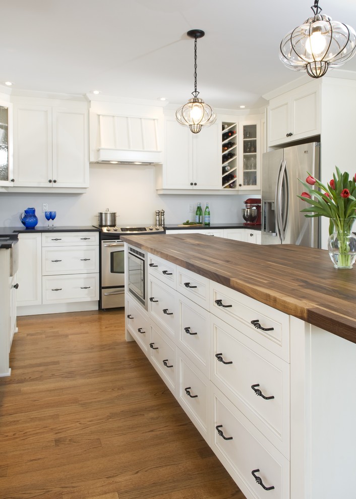 Foto de cocina tradicional con electrodomésticos de acero inoxidable y encimera de madera