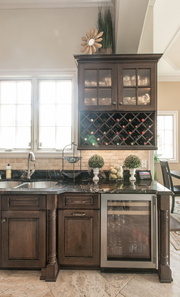 Example of a large classic u-shaped eat-in kitchen design in Orlando with raised-panel cabinets, brown cabinets, granite countertops, beige backsplash, stone tile backsplash and an island