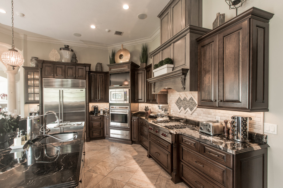 This is an example of a large traditional u-shaped kitchen/diner in Orlando with raised-panel cabinets, brown cabinets, granite worktops, beige splashback, stone tiled splashback and an island.
