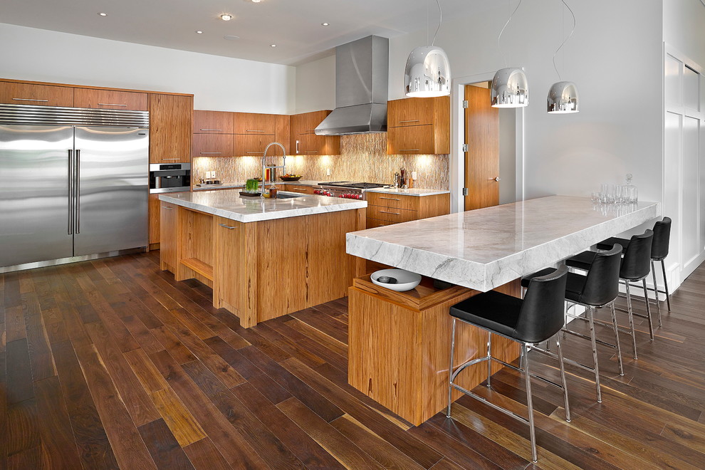 This is an example of a large contemporary l-shaped open plan kitchen in Edmonton with a double-bowl sink, flat-panel cabinets, medium wood cabinets, granite worktops, multi-coloured splashback, mosaic tiled splashback, stainless steel appliances, dark hardwood flooring and multiple islands.