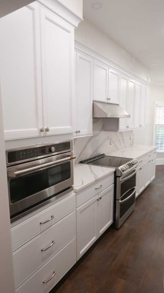 Exempel på ett mellanstort klassiskt vit vitt kök, med en rustik diskho, skåp i shakerstil, vita skåp, bänkskiva i kvarts, vitt stänkskydd, rostfria vitvaror, laminatgolv och flerfärgat golv