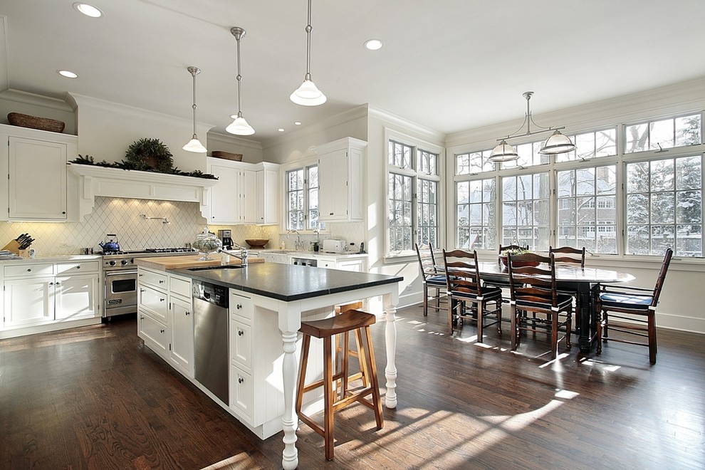Immagine di una cucina abitabile tradizionale con ante in stile shaker, ante bianche, paraspruzzi bianco e elettrodomestici in acciaio inossidabile