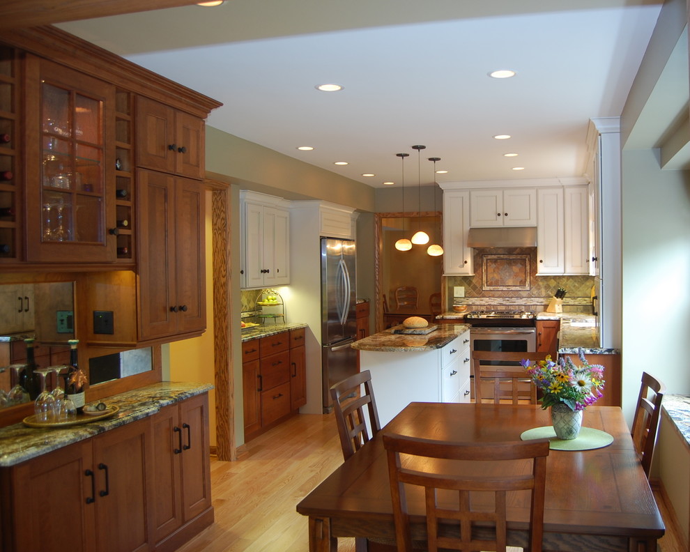 Mid-sized elegant u-shaped light wood floor and brown floor eat-in kitchen photo in Chicago with stainless steel appliances, an undermount sink, flat-panel cabinets, granite countertops, porcelain backsplash, an island, white cabinets and multicolored backsplash