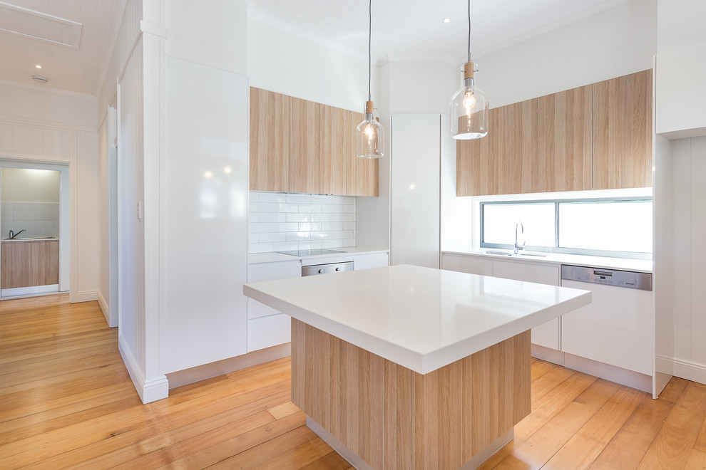 Zweizeilige Moderne Wohnküche mit Unterbauwaschbecken, offenen Schränken, hellen Holzschränken, Glas-Arbeitsplatte, Küchenrückwand in Weiß, Rückwand aus Keramikfliesen, Küchengeräten aus Edelstahl, braunem Holzboden und Kücheninsel in Brisbane