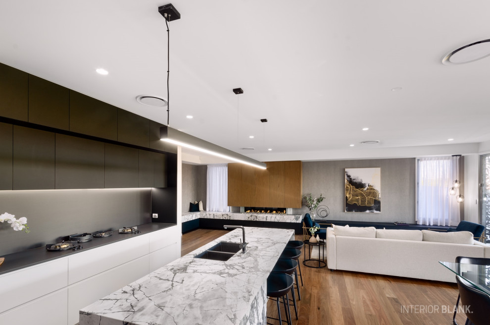 Idéer för mycket stora funkis flerfärgat kök med öppen planlösning, med en undermonterad diskho, släta luckor, vita skåp, marmorbänkskiva, svart stänkskydd, stänkskydd i sten, svarta vitvaror, mellanmörkt trägolv, en köksö och brunt golv