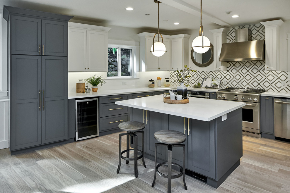 Kitchen - transitional l-shaped light wood floor and beige floor kitchen idea in San Francisco with shaker cabinets, gray cabinets, stainless steel appliances, an island and white countertops