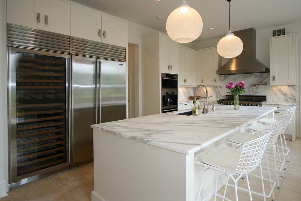 Foto di una cucina a L minimal con lavello sottopiano, ante con riquadro incassato, ante bianche, paraspruzzi bianco e elettrodomestici in acciaio inossidabile