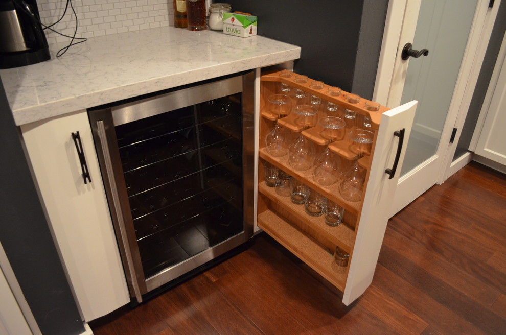 Trendy dark wood floor kitchen photo in Sacramento with white cabinets, white backsplash and stainless steel appliances