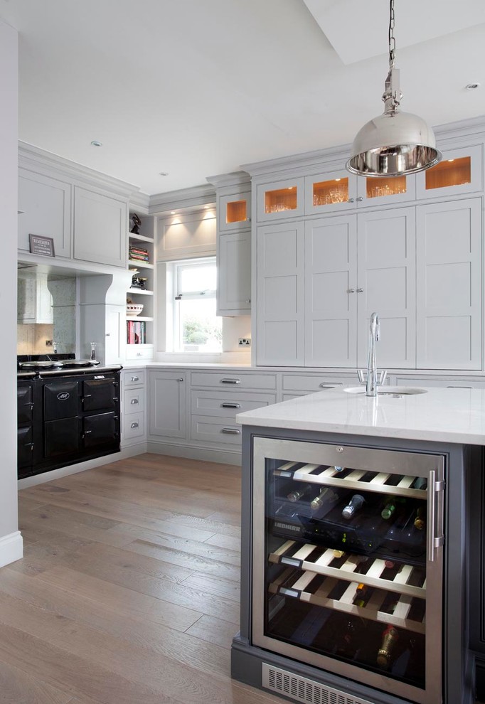 Inspiration for a classic l-shaped kitchen/diner in Dublin with a double-bowl sink, beaded cabinets, grey cabinets, engineered stone countertops and black appliances.