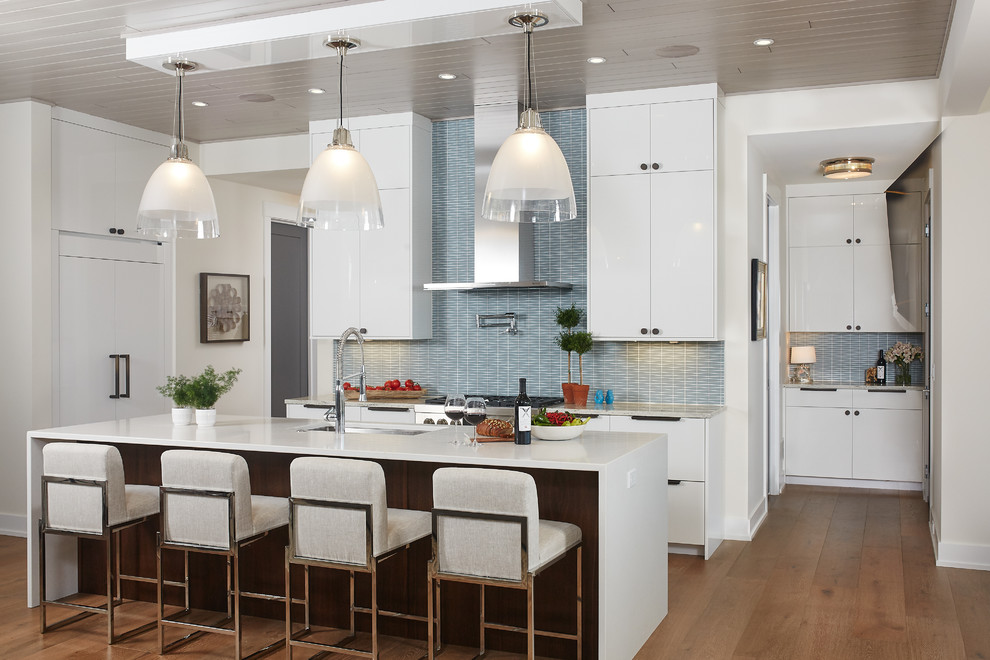 Kitchen - contemporary l-shaped medium tone wood floor and brown floor kitchen idea in Grand Rapids with an undermount sink, flat-panel cabinets, white cabinets, blue backsplash, matchstick tile backsplash, paneled appliances, an island and white countertops