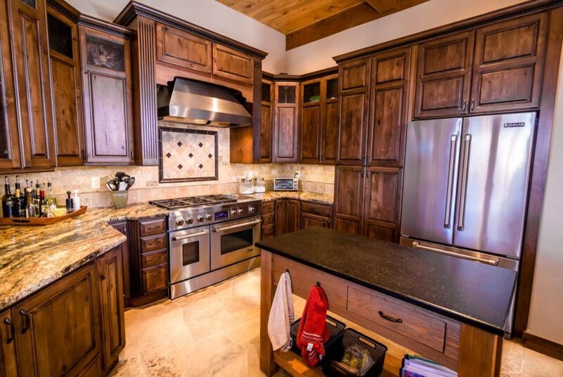Idéer för att renovera ett stort rustikt kök, med en rustik diskho, luckor med upphöjd panel, skåp i mellenmörkt trä, granitbänkskiva, beige stänkskydd, rostfria vitvaror, en halv köksö och beiget golv
