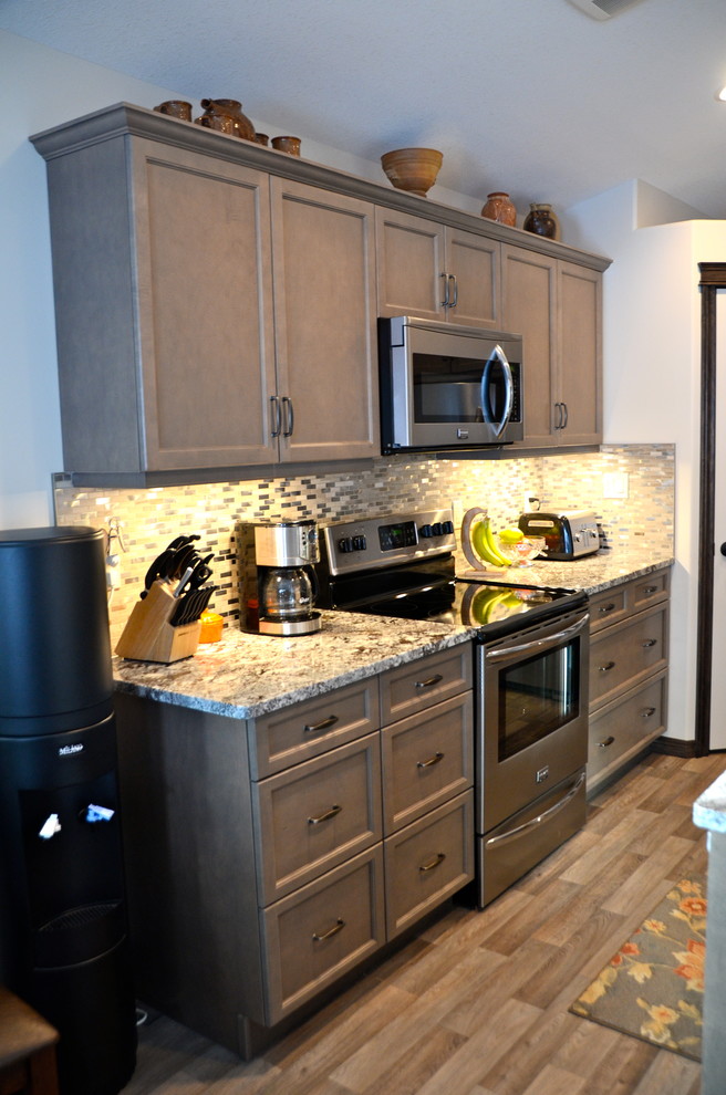 Maritime Wohnküche in L-Form mit Unterbauwaschbecken, flächenbündigen Schrankfronten, grauen Schränken, Granit-Arbeitsplatte, Küchenrückwand in Grau, Rückwand aus Mosaikfliesen und Küchengeräten aus Edelstahl in Calgary