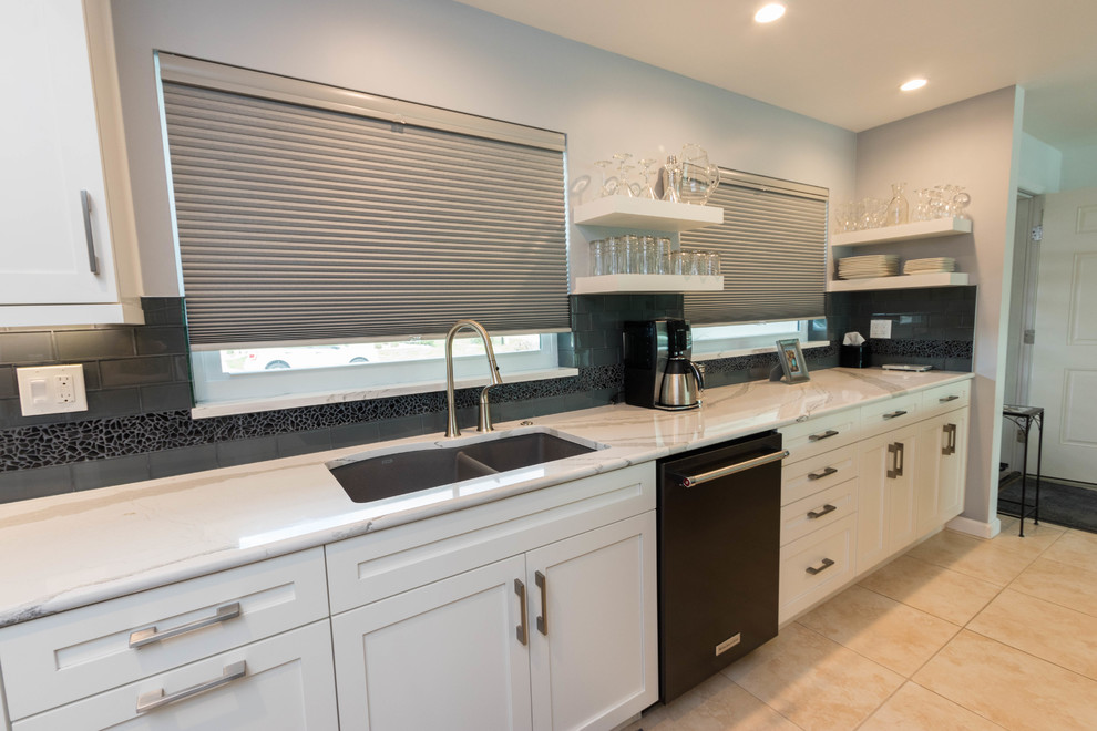 Mid-sized transitional galley ceramic tile open concept kitchen photo in Miami with a single-bowl sink, shaker cabinets, white cabinets, quartz countertops, black backsplash, glass tile backsplash, black appliances and a peninsula