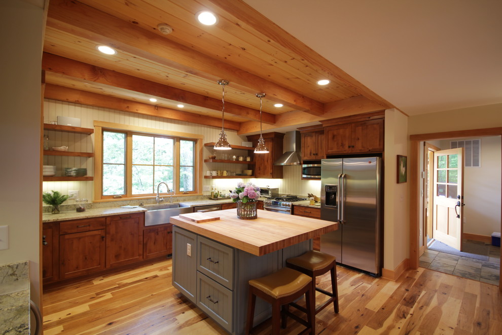 Inspiration for a mid-sized craftsman u-shaped eat-in kitchen remodel in Richmond with a farmhouse sink, recessed-panel cabinets, dark wood cabinets, wood countertops, white backsplash and an island