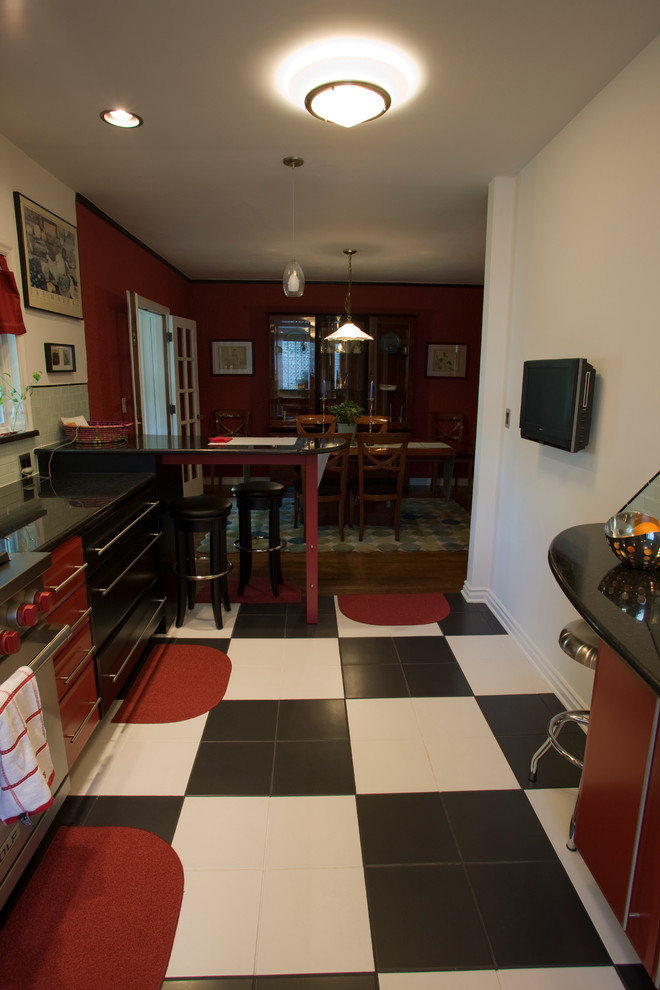 Small modern l-shaped kitchen/diner in Indianapolis with a submerged sink, flat-panel cabinets, black cabinets, granite worktops, multi-coloured splashback, glass tiled splashback, stainless steel appliances, ceramic flooring and a breakfast bar.
