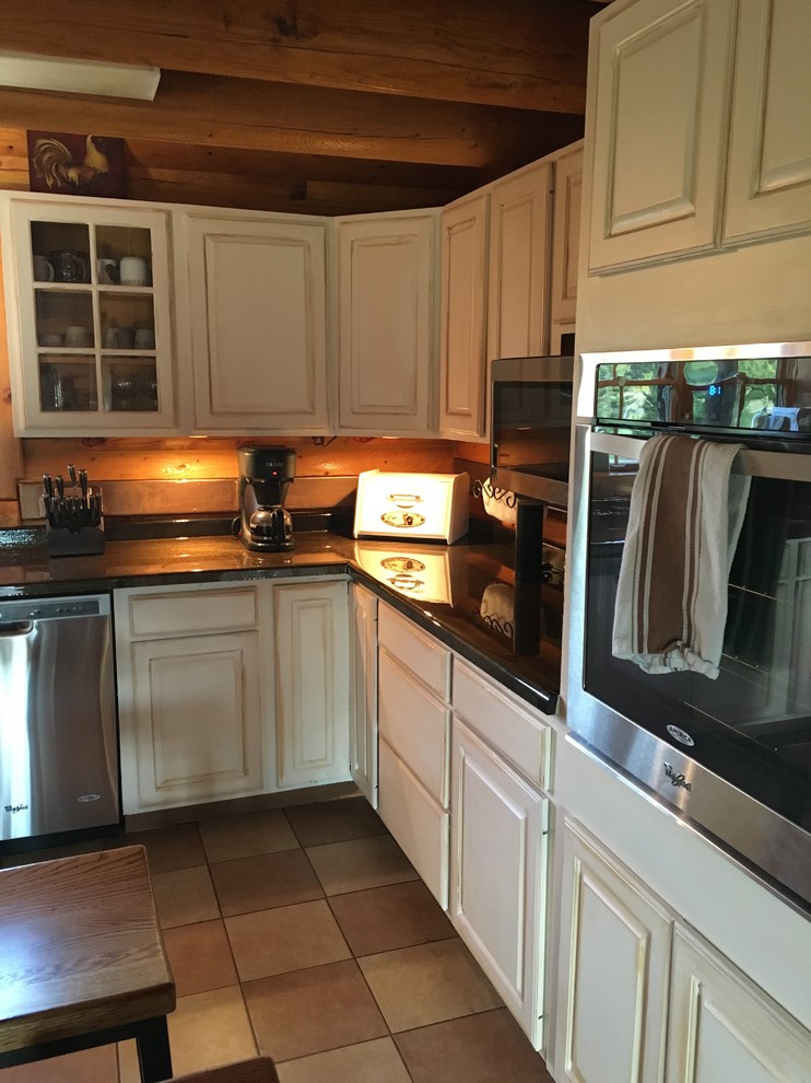 Exempel på ett stort rustikt kök, med en rustik diskho, luckor med upphöjd panel, vita skåp, stänkskydd med metallisk yta, rostfria vitvaror och en köksö