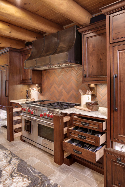 Inredning av ett rustikt avskilt, stort l-kök, med luckor med upphöjd panel, skåp i mellenmörkt trä, granitbänkskiva, rött stänkskydd, stänkskydd i terrakottakakel, rostfria vitvaror och en köksö