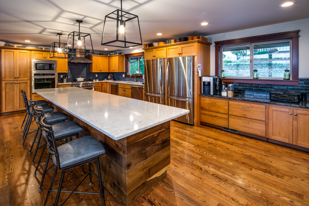 Exempel på ett stort modernt grå grått kök, med en undermonterad diskho, skåp i shakerstil, bruna skåp, bänkskiva i kvartsit, svart stänkskydd, stänkskydd i porslinskakel, rostfria vitvaror, mörkt trägolv, en köksö och brunt golv