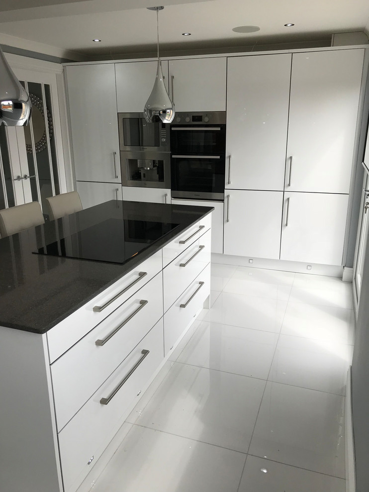 Idéer för ett mellanstort modernt svart linjärt kök med öppen planlösning, med släta luckor, vita skåp, bänkskiva i kvartsit, rostfria vitvaror, klinkergolv i keramik, en köksö och vitt golv
