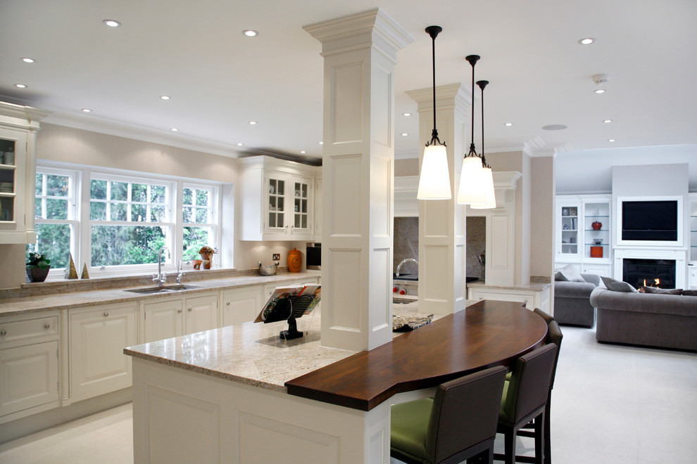 Inspiration for a large modern l-shaped open plan kitchen in Sussex with a built-in sink, raised-panel cabinets, white cabinets, marble worktops, beige splashback, integrated appliances and an island.