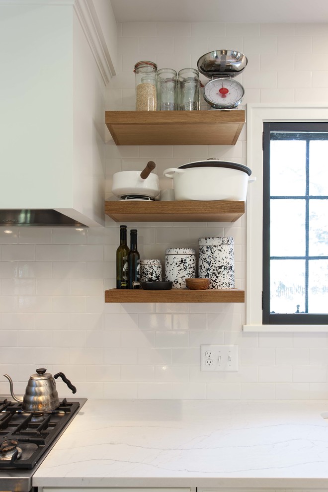 Modern inredning av ett mellanstort kök, med en rustik diskho, luckor med infälld panel, svarta skåp, träbänkskiva, integrerade vitvaror, cementgolv och en halv köksö