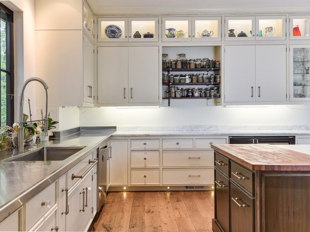 Eat-in kitchen - large transitional l-shaped medium tone wood floor and brown floor eat-in kitchen idea in Other with an undermount sink, beaded inset cabinets, white cabinets, marble countertops, white backsplash, stone slab backsplash, stainless steel appliances and an island