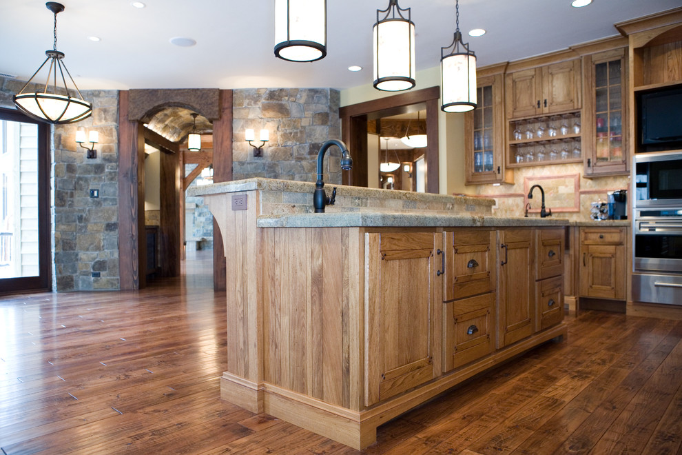 Eat-in kitchen - large rustic u-shaped medium tone wood floor eat-in kitchen idea in Salt Lake City with an undermount sink, recessed-panel cabinets, medium tone wood cabinets, granite countertops, multicolored backsplash, stone tile backsplash, stainless steel appliances and two islands
