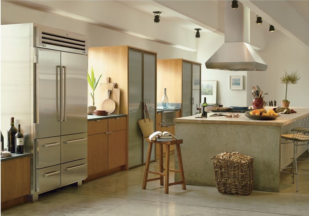 Inredning av ett modernt mellanstort kök, med en rustik diskho, släta luckor, skåp i mellenmörkt trä, bänkskiva i koppar, rostfria vitvaror, betonggolv, en köksö och grått golv