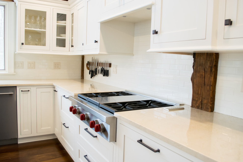 Mid-sized farmhouse u-shaped medium tone wood floor and brown floor eat-in kitchen photo in Cleveland with a farmhouse sink, recessed-panel cabinets, white cabinets, wood countertops, white backsplash, subway tile backsplash, stainless steel appliances, an island and white countertops