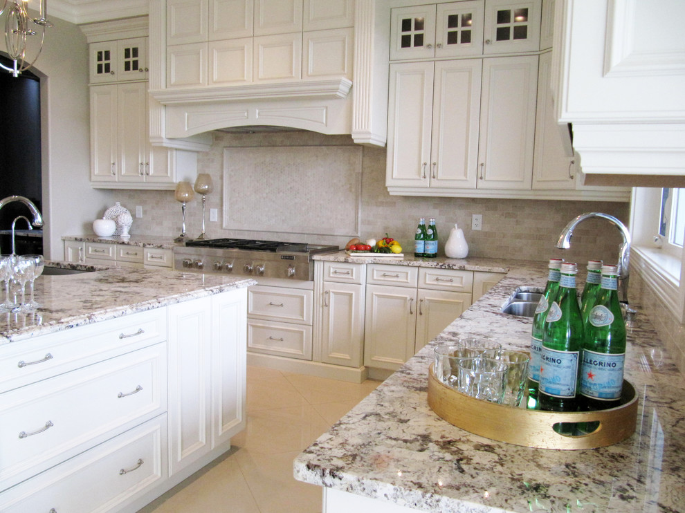 Exempel på ett stort klassiskt kök, med en undermonterad diskho, luckor med infälld panel, vita skåp, granitbänkskiva, beige stänkskydd, stänkskydd i stenkakel, rostfria vitvaror, marmorgolv och en köksö