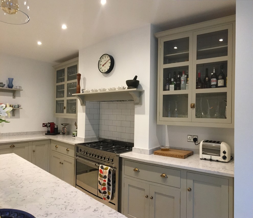 Klassisk inredning av ett mellanstort kök, med en rustik diskho, skåp i shakerstil, grå skåp, marmorbänkskiva, vitt stänkskydd, stänkskydd i keramik, rostfria vitvaror, kalkstensgolv, en köksö och beiget golv