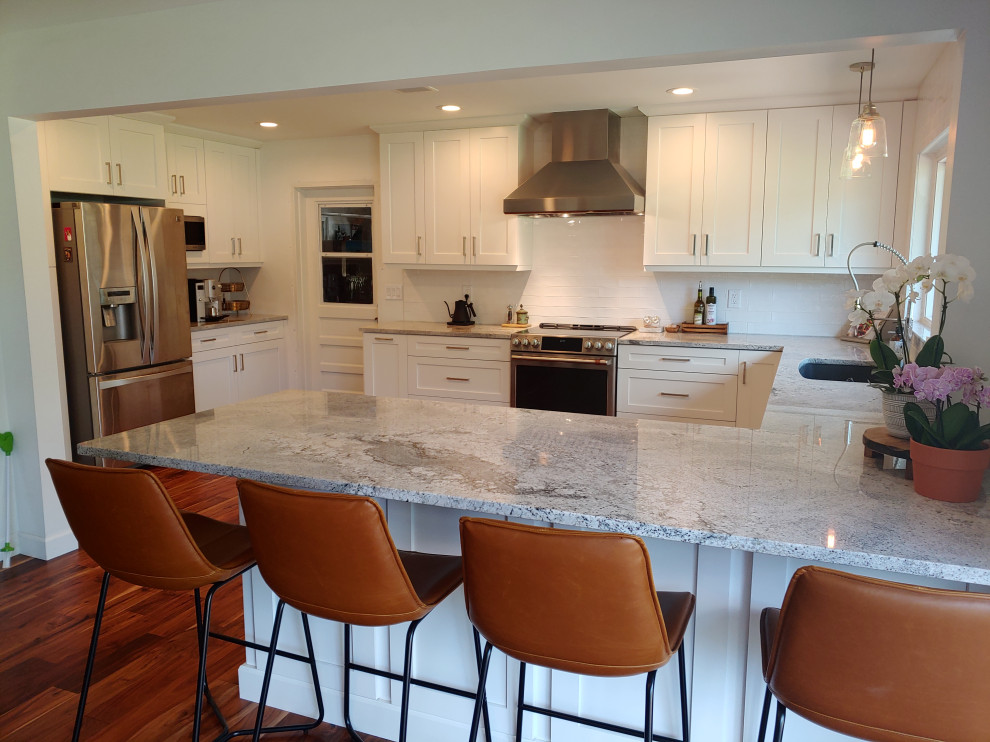 Example of a large country u-shaped medium tone wood floor and brown floor eat-in kitchen design in Tampa with a single-bowl sink, shaker cabinets, white cabinets, quartzite countertops, white backsplash, subway tile backsplash, stainless steel appliances, a peninsula and white countertops