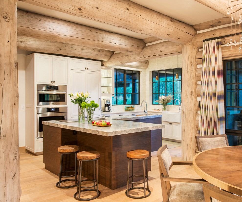 Urige Wohnküche in L-Form mit Landhausspüle, Schrankfronten im Shaker-Stil, beigen Schränken, Rückwand-Fenster, Küchengeräten aus Edelstahl und hellem Holzboden in Denver