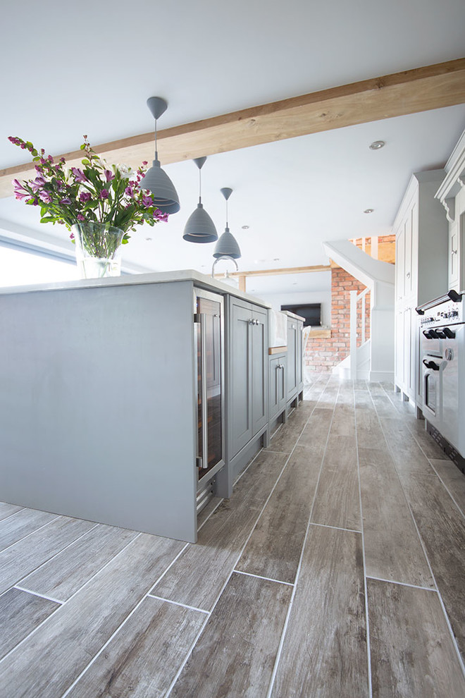 Aménagement d'une grande cuisine ouverte linéaire contemporaine avec un placard à porte shaker, un sol en carrelage de porcelaine, îlot et un sol gris.