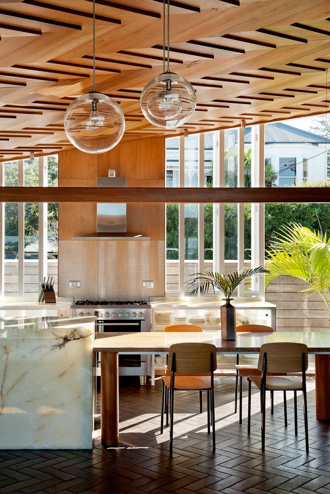 Example of a trendy galley eat-in kitchen design in Auckland with metallic backsplash, stainless steel appliances, an island and marble countertops