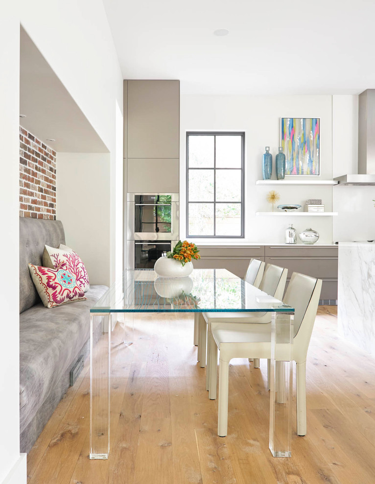Moderne Wohnküche mit flächenbündigen Schrankfronten, grauen Schränken, Küchenrückwand in Weiß, Küchengeräten aus Edelstahl, hellem Holzboden und weißer Arbeitsplatte in Dallas