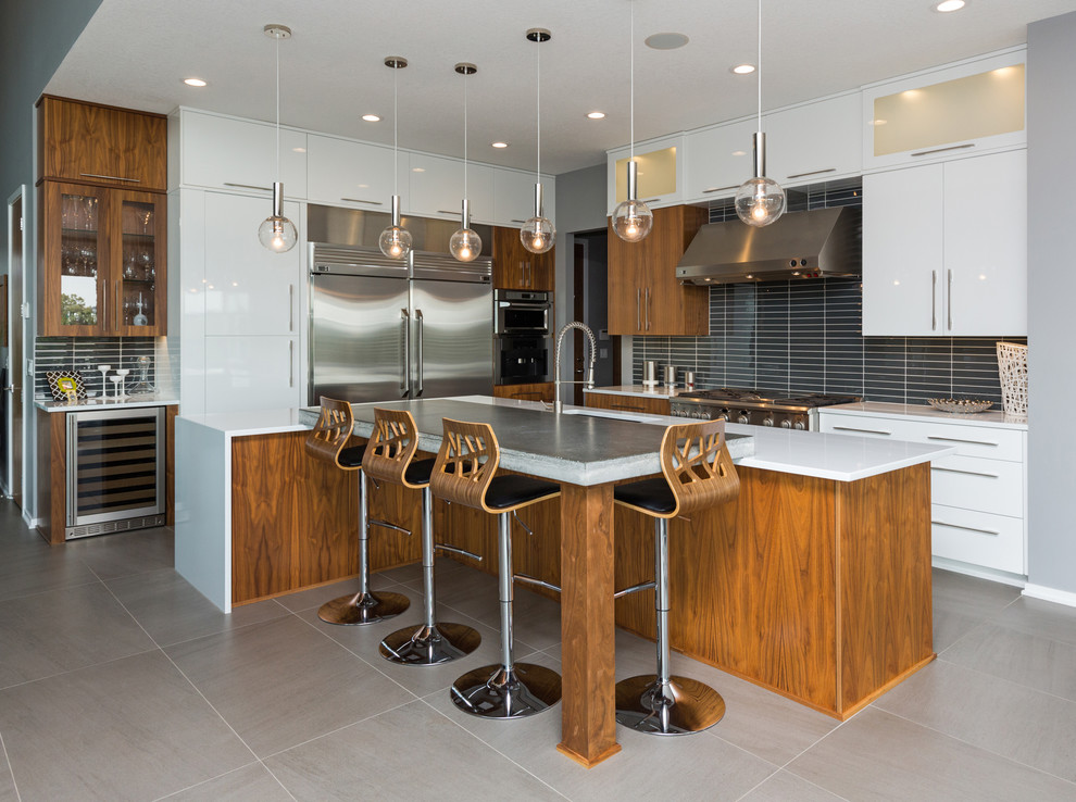 Moderne Küche in L-Form mit Unterbauwaschbecken, flächenbündigen Schrankfronten, weißen Schränken, Küchenrückwand in Schwarz und Kücheninsel in Sonstige