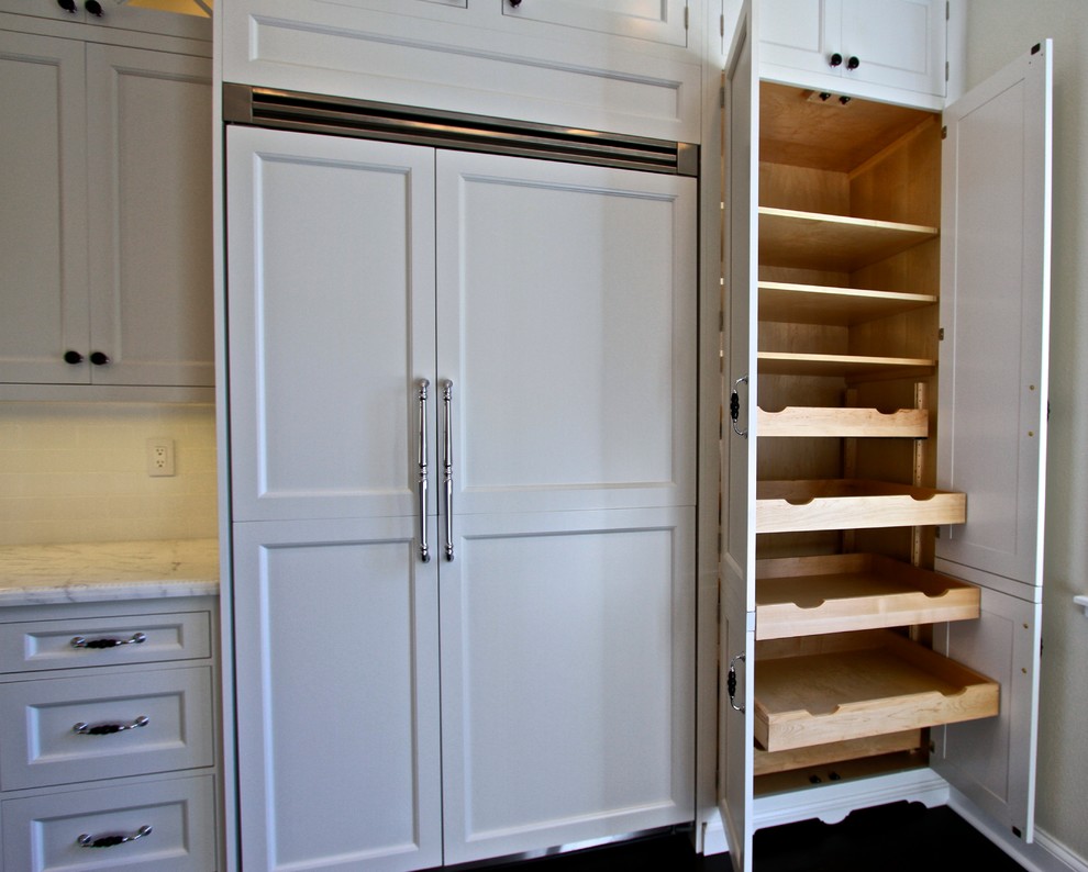 Bild på ett mellanstort vintage kök, med en rustik diskho, luckor med infälld panel, vita skåp, marmorbänkskiva, vitt stänkskydd, stänkskydd i keramik, rostfria vitvaror, mörkt trägolv och en köksö