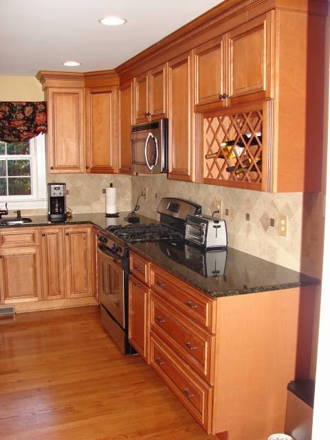 Exempel på ett mellanstort klassiskt kök, med luckor med upphöjd panel, skåp i ljust trä, granitbänkskiva, flerfärgad stänkskydd, stänkskydd i terrakottakakel, rostfria vitvaror, ljust trägolv och en köksö