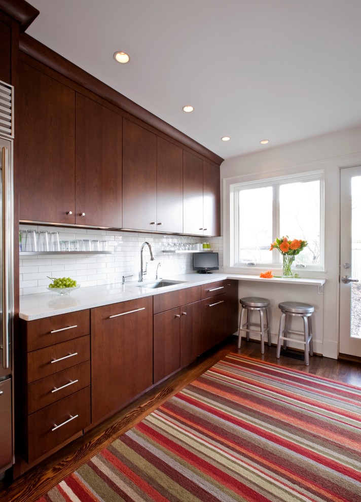 Inspiration for a contemporary galley enclosed kitchen remodel in DC Metro with an undermount sink, medium tone wood cabinets, quartz countertops, white backsplash, subway tile backsplash and stainless steel appliances