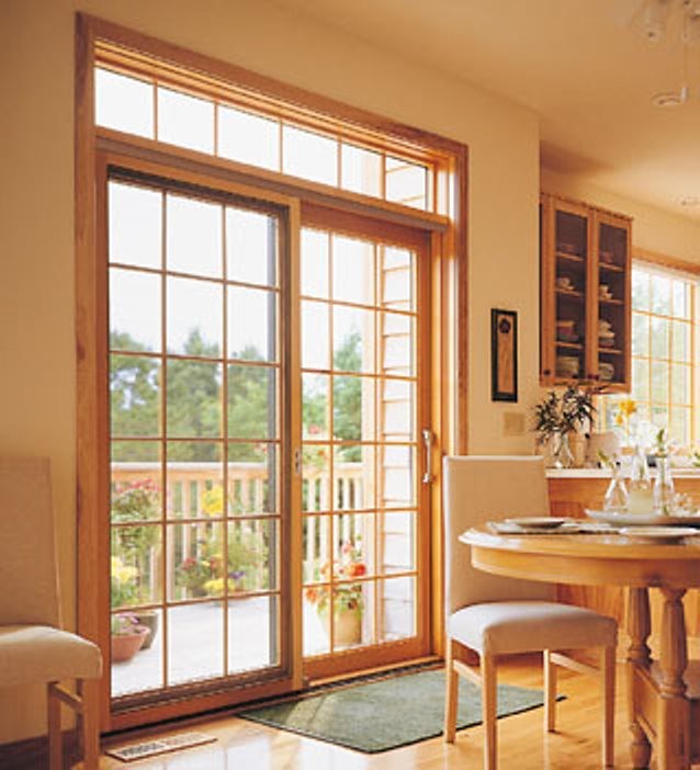 Ejemplo de cocina clásica abierta con armarios tipo vitrina, puertas de armario de madera clara y suelo de madera clara