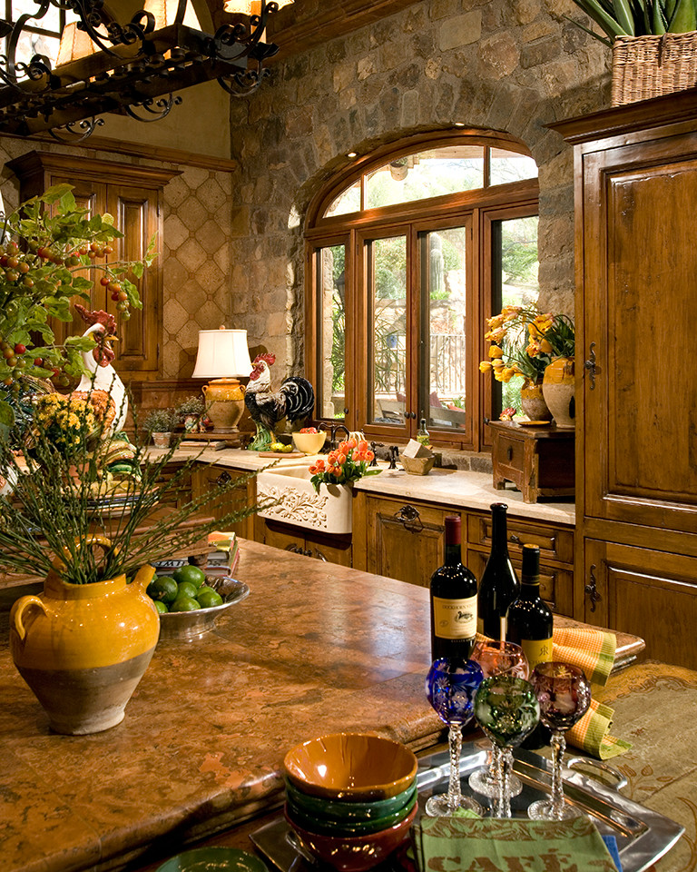 Large tuscan l-shaped limestone floor and beige floor kitchen photo in Phoenix with a farmhouse sink, raised-panel cabinets, limestone countertops, paneled appliances, an island, beige countertops and medium tone wood cabinets