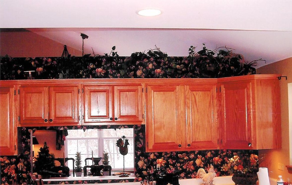 На фото: отдельная кухня среднего размера в классическом стиле с фасадами с выступающей филенкой и фасадами цвета дерева среднего тона с