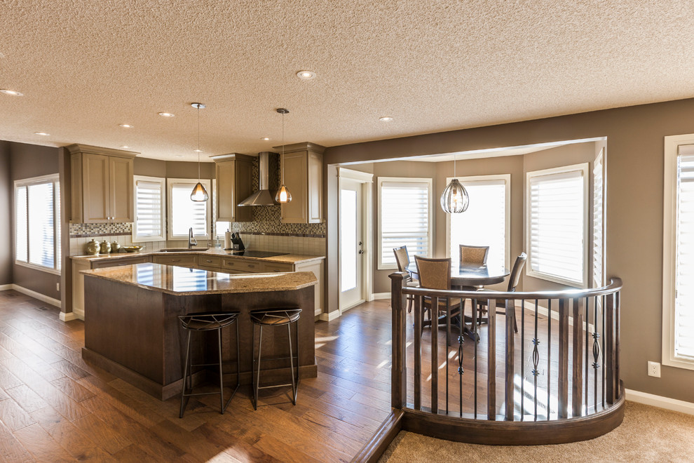 Mittelgroße Moderne Wohnküche in L-Form mit Unterbauwaschbecken, Schrankfronten mit vertiefter Füllung, weißen Schränken, Küchenrückwand in Weiß, Küchengeräten aus Edelstahl, braunem Holzboden und Kücheninsel in Calgary