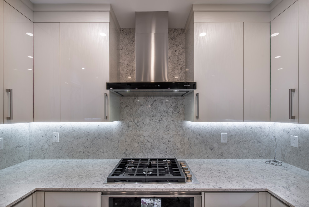 Foto på ett stort funkis grå kök, med en undermonterad diskho, släta luckor, vita skåp, marmorbänkskiva, grått stänkskydd, stänkskydd i sten, rostfria vitvaror, marmorgolv, en halv köksö och grått golv