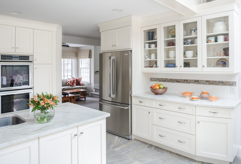 Mid-sized elegant l-shaped ceramic tile eat-in kitchen photo in New York with an undermount sink, shaker cabinets, white cabinets, marble countertops, white backsplash, subway tile backsplash, stainless steel appliances and no island