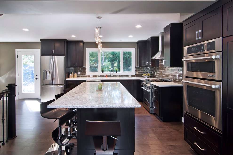 Moderne Küche in L-Form mit Küchengeräten aus Edelstahl, Rückwand aus Metrofliesen, Schrankfronten im Shaker-Stil, dunklen Holzschränken und Küchenrückwand in Grau in Minneapolis